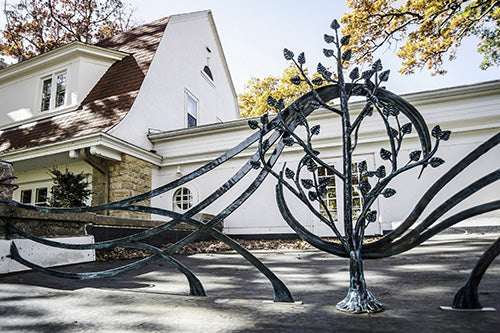 Hand forged wrought iron gate and railing with hand welded tree with twisted stems wrapping around rocks